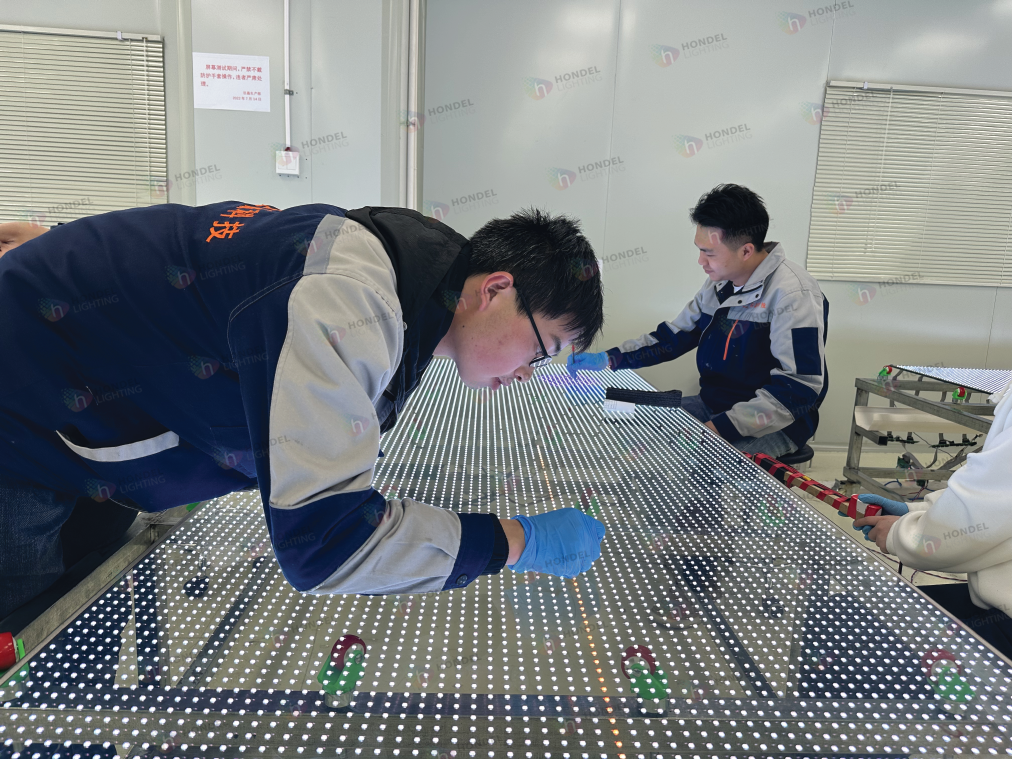 Quality control team inspecting a large-scale transparent LED display panel at our China factory