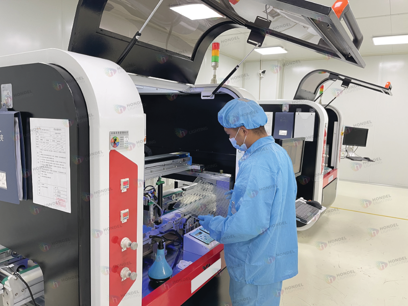Hondel technician operating advanced automated production machinery for transparent LED glass screens